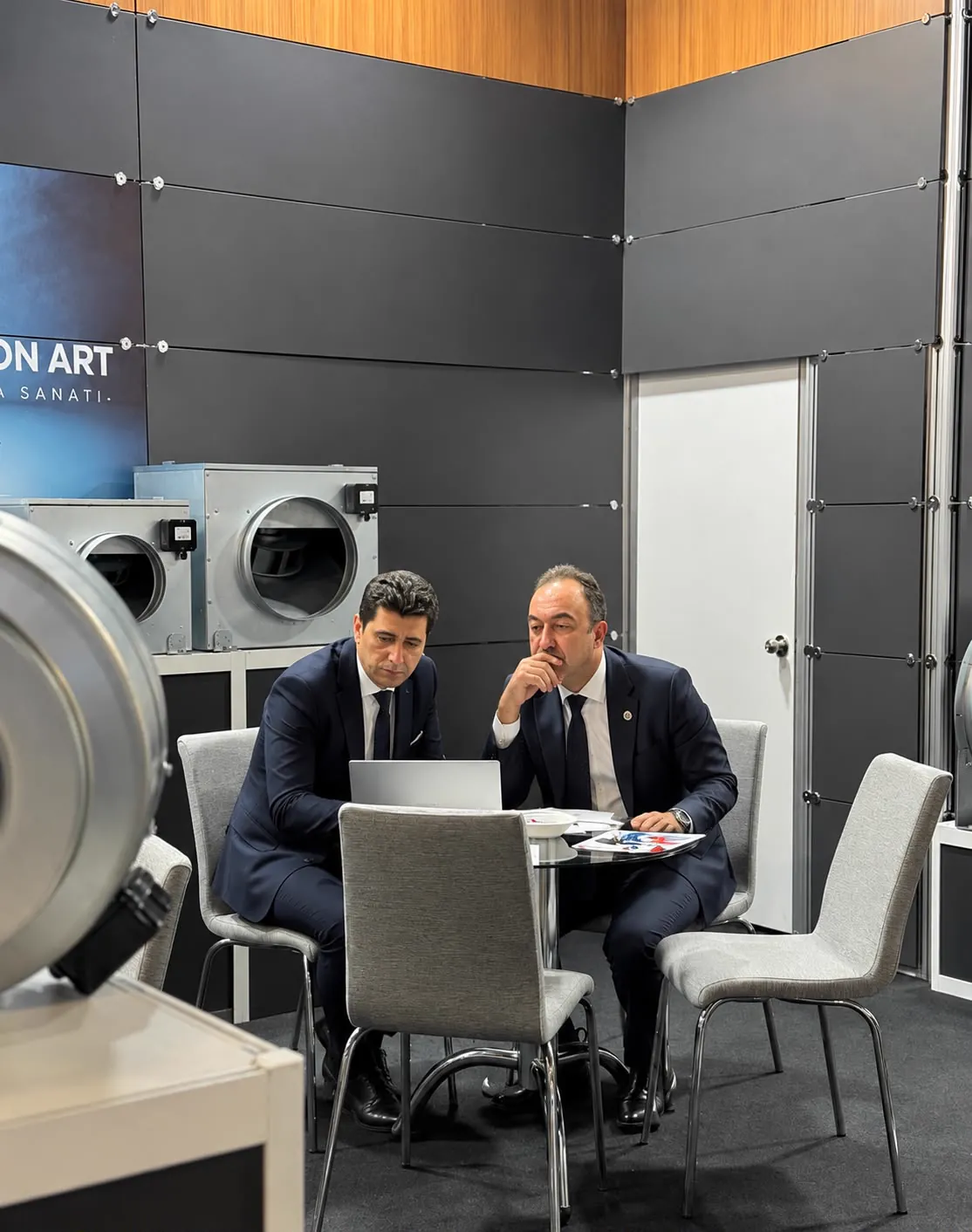 Deux experts de Central Air Concept étudient un projet de ventilation, matériel d'extraction en arrière-plan