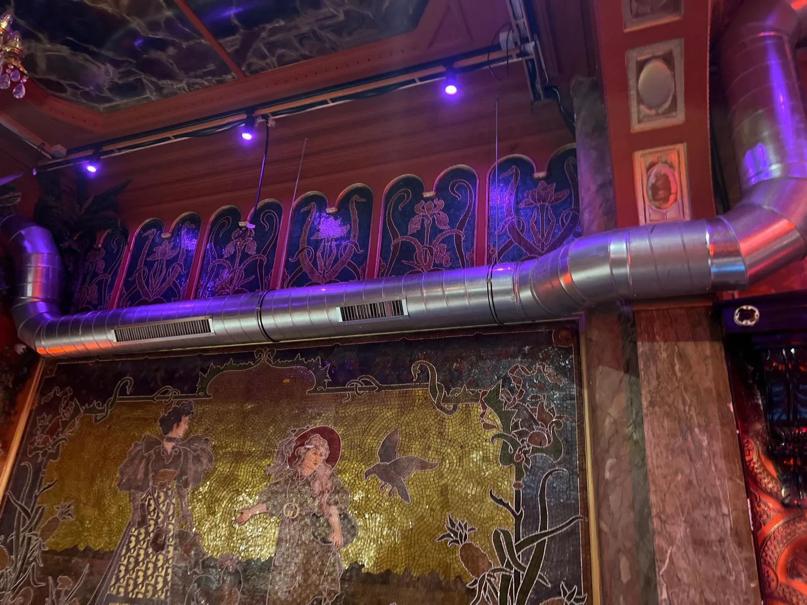 Réseau d'extraction en gaine inox apparente intégré à un intérieur Art nouveau à mosaïques dorées d'un établissement bruxellois de prestige